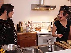 Three awesome brunettes wearing aprons share a wang in the kitchen