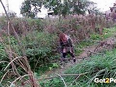 Redhead opens her legs to piss outdoors