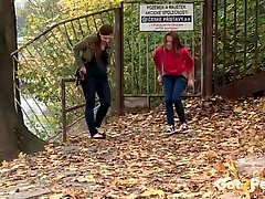 Two cute girls pee in the leaves outdoors