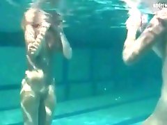 Two naked beauties swim in the pool
